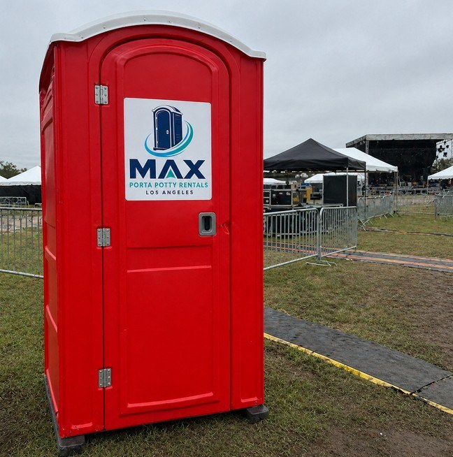 Red porta potty unit set up at a music festival